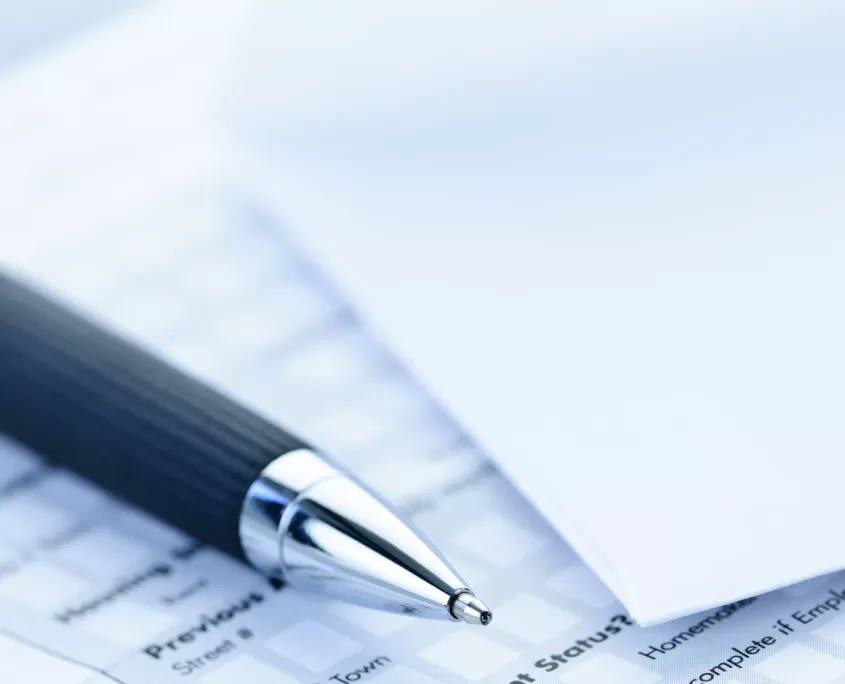 Blank credit application form with envelope and pen close up